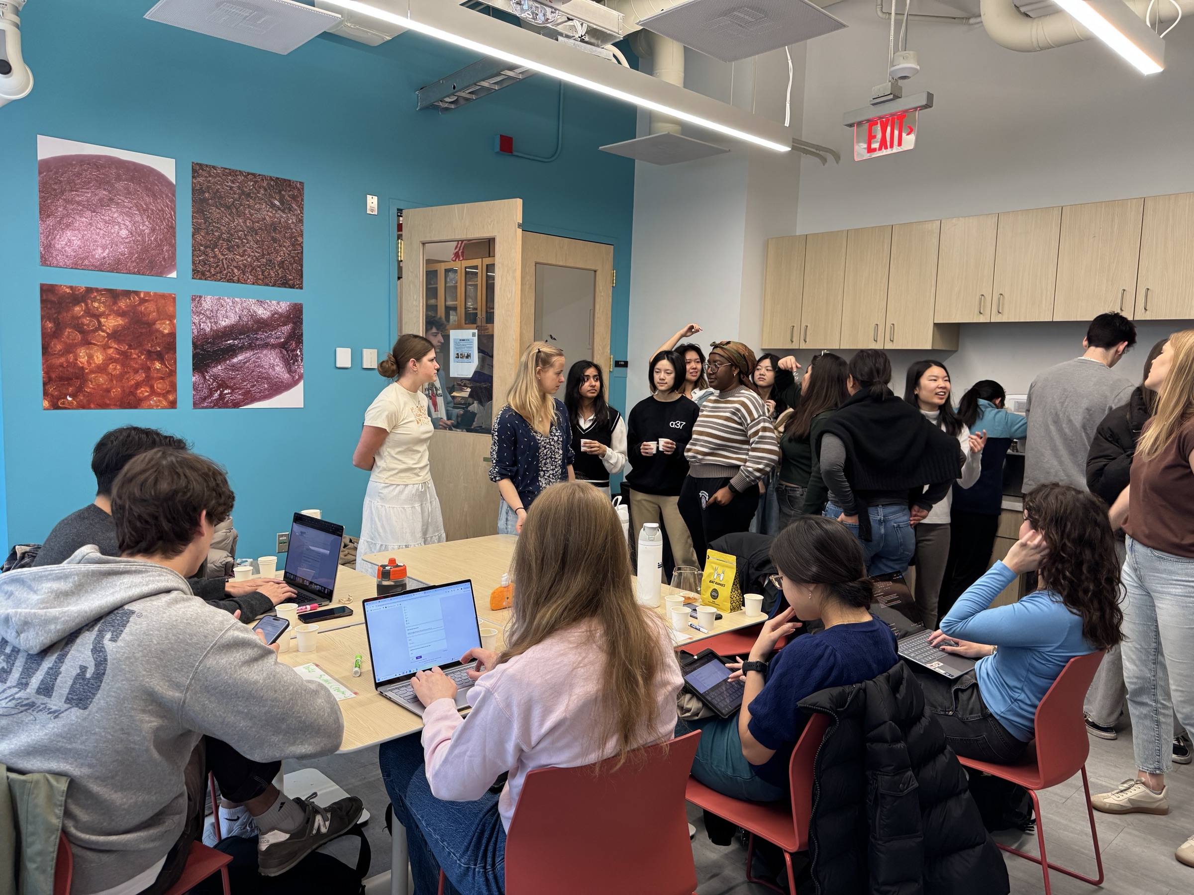 Students seated at tables with laptops and gathered near the coffee counter during a 3.000 Coffee Matters brewing competition.